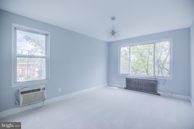 spare room with carpet floors, radiator heating unit, a wall unit AC, and baseboards