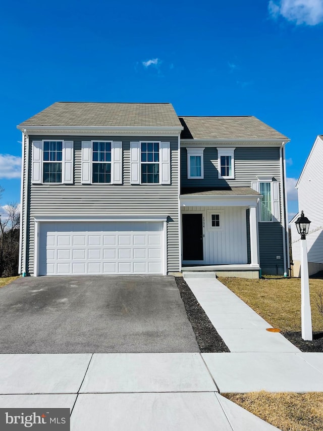 view of front of property with an attached garage, aphalt driveway, and board and batten siding