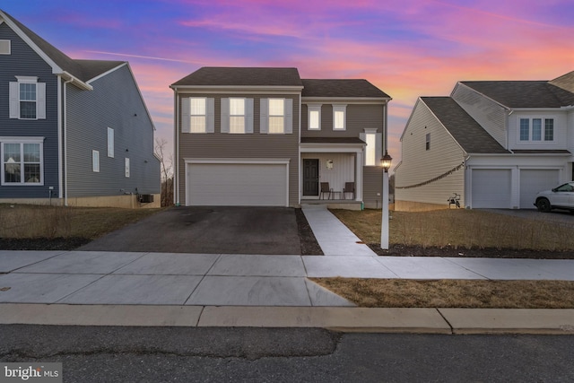 traditional home featuring an attached garage and driveway