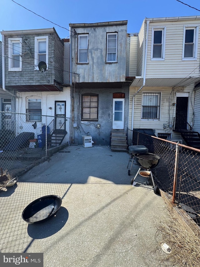 back of house featuring entry steps and fence