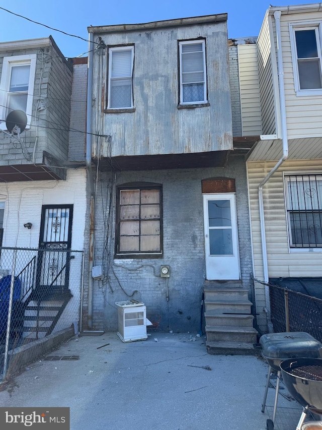 townhome / multi-family property featuring entry steps, fence, and brick siding