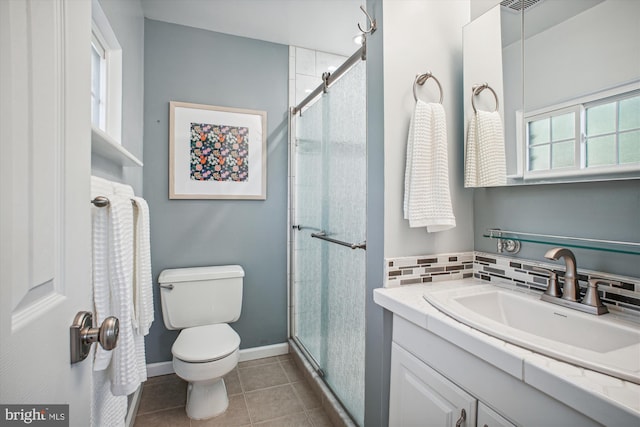 full bathroom featuring tile patterned floors, toilet, a stall shower, tasteful backsplash, and vanity