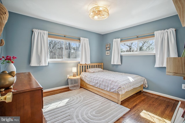 bedroom with baseboards and wood finished floors