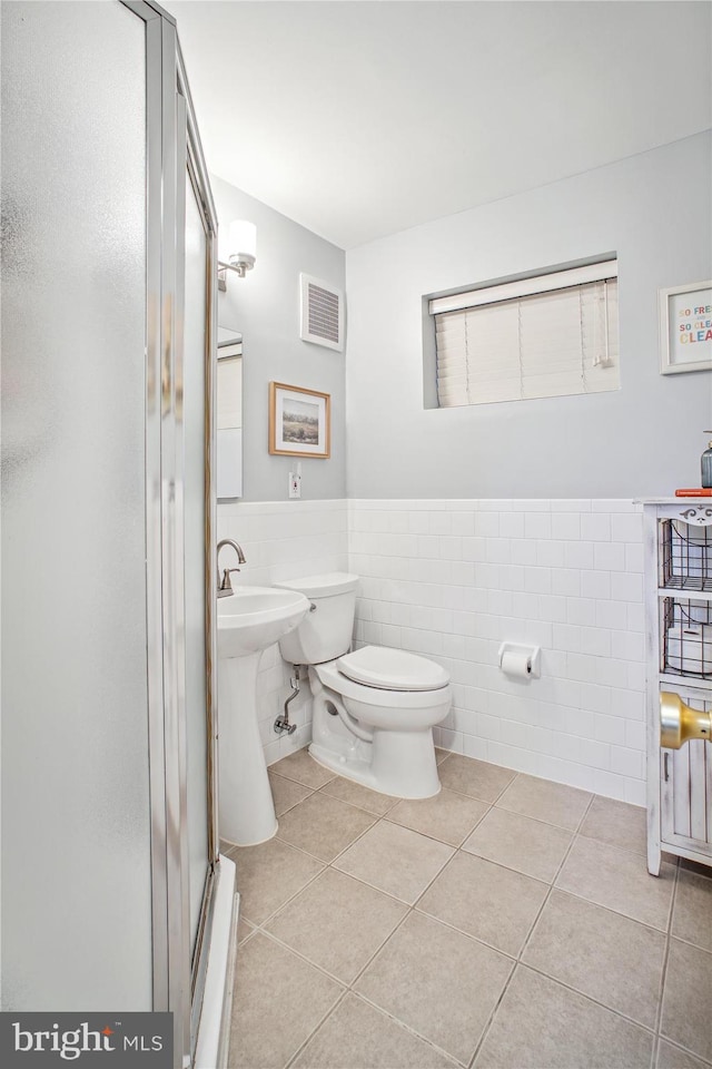 full bath featuring visible vents, a shower stall, wainscoting, tile patterned floors, and toilet