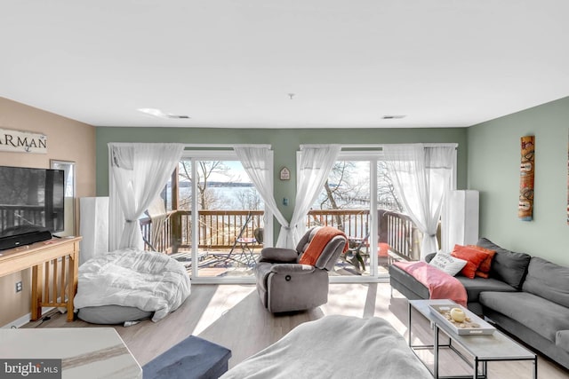 living area with visible vents and wood finished floors