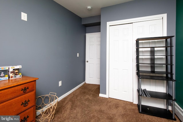 bedroom with dark colored carpet, a closet, and baseboards