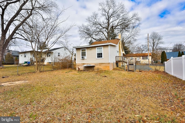 rear view of property with a lawn and a fenced backyard