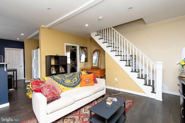 living room featuring stacked washer / drying machine, stairway, baseboards, and wood finished floors