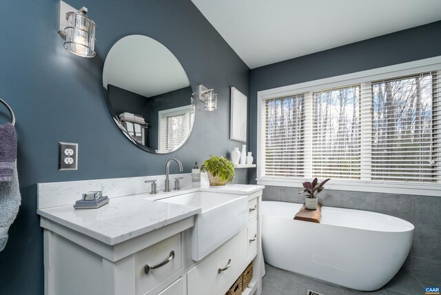 full bathroom featuring a soaking tub and vanity