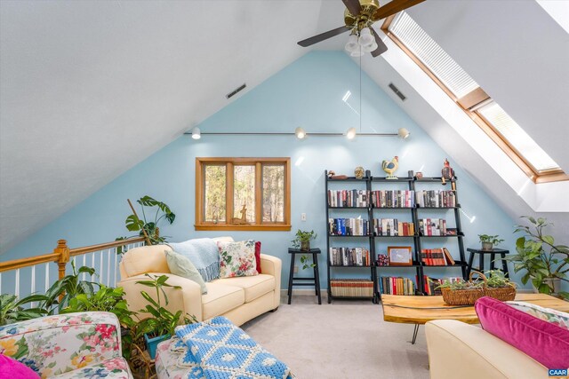 living room with carpet, visible vents, vaulted ceiling with skylight, and ceiling fan