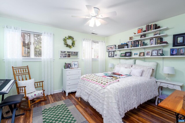 bedroom with ceiling fan, wood finished floors, visible vents, and baseboards