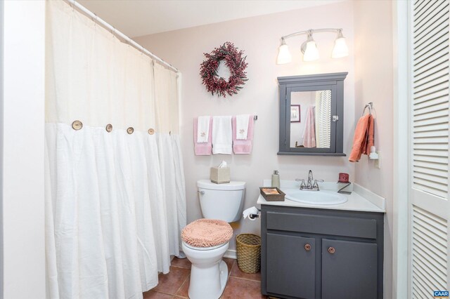 full bathroom featuring toilet, vanity, a closet, and tile patterned floors