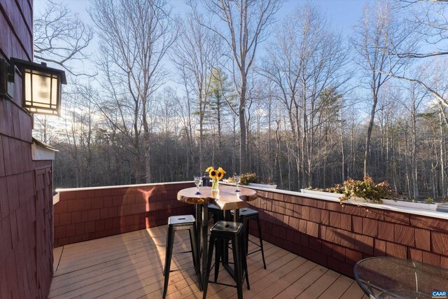 wooden deck with a wooded view