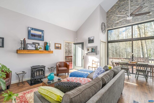 living room with plenty of natural light, wood finished floors, and a wood stove