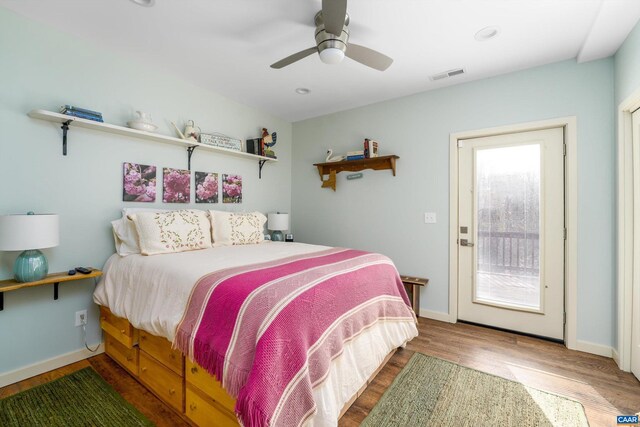 bedroom featuring visible vents, ceiling fan, baseboards, and wood finished floors