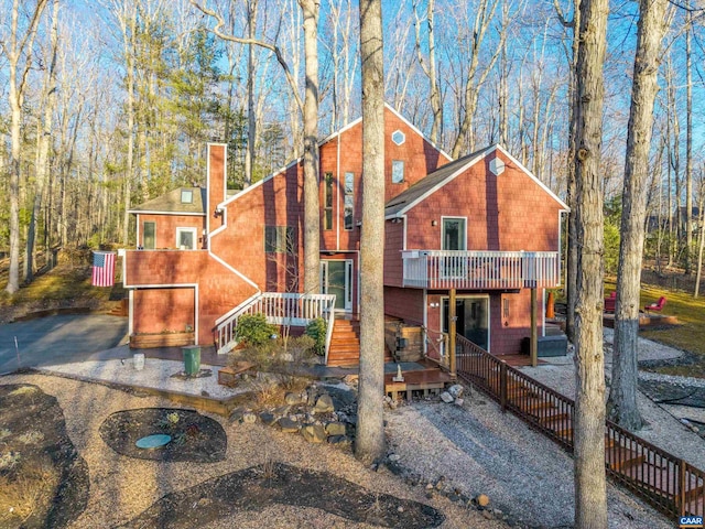 chalet / cabin featuring a chimney and a wooden deck