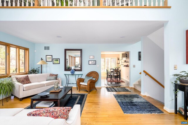 living room with a healthy amount of sunlight, visible vents, and wood finished floors