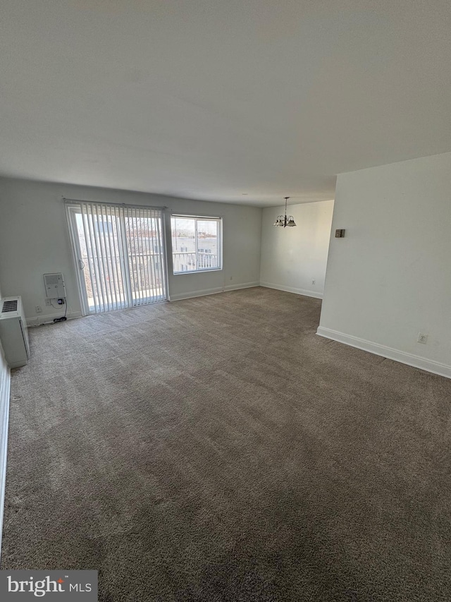 interior space with a notable chandelier, carpet floors, and baseboards