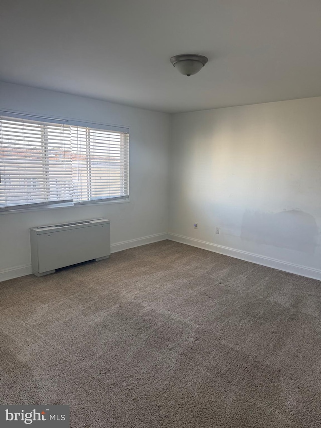 unfurnished room featuring carpet floors and baseboards