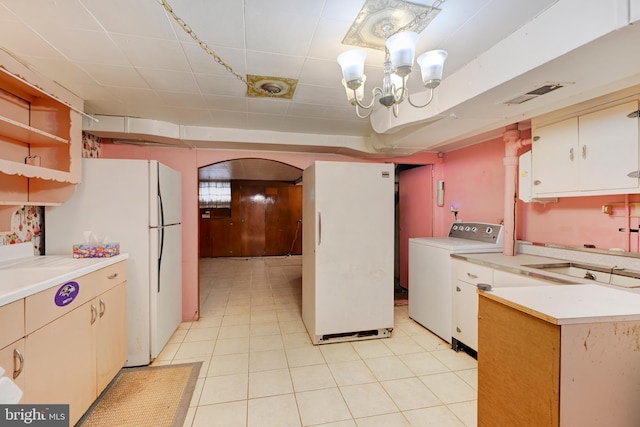 kitchen with washer / clothes dryer, light countertops, and freestanding refrigerator