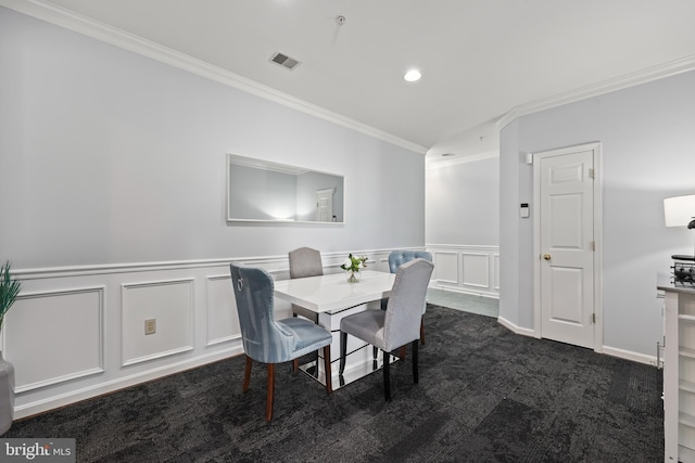 dining area featuring carpet floors, ornamental molding, visible vents, and a decorative wall