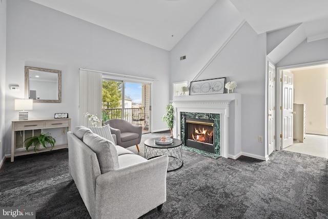 living room featuring visible vents, a high end fireplace, carpet flooring, high vaulted ceiling, and baseboards