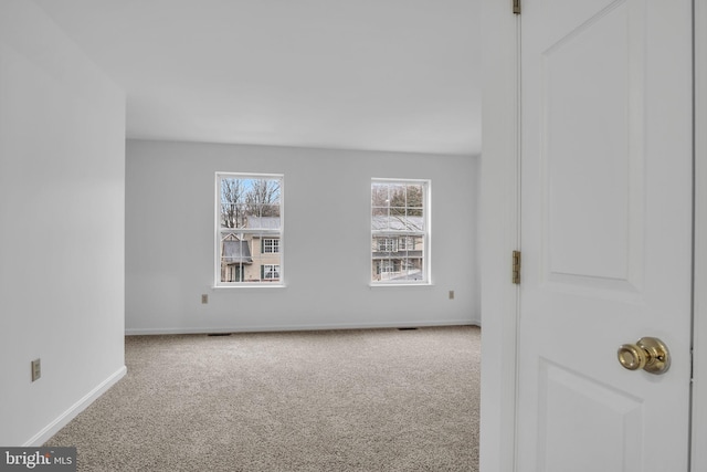 carpeted spare room with baseboards