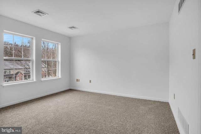 carpeted spare room with baseboards and visible vents