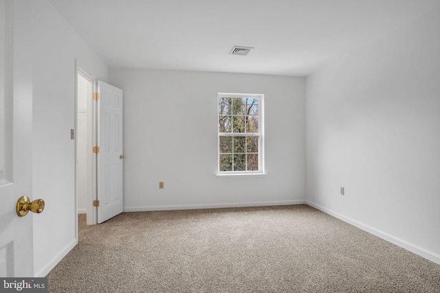 spare room with baseboards, visible vents, and carpet flooring