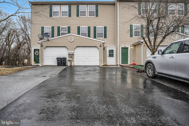 multi unit property with a garage and aphalt driveway