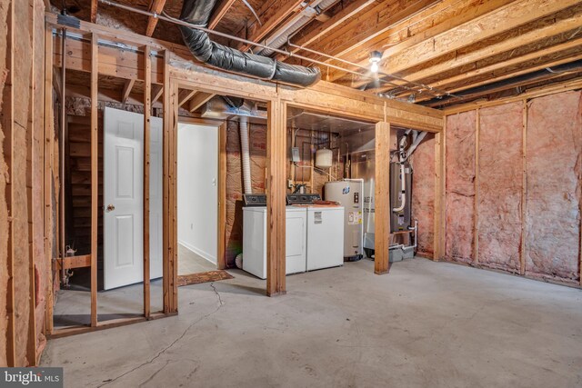 unfinished basement with washing machine and clothes dryer and electric water heater