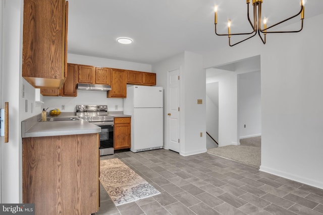 kitchen with electric range, freestanding refrigerator, light countertops, under cabinet range hood, and a sink