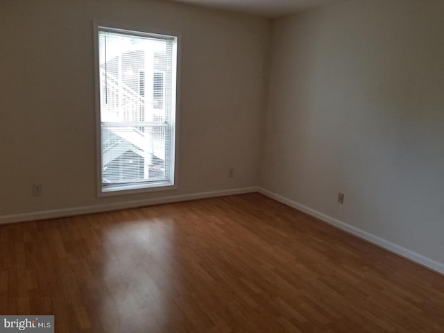 empty room with baseboards and wood finished floors