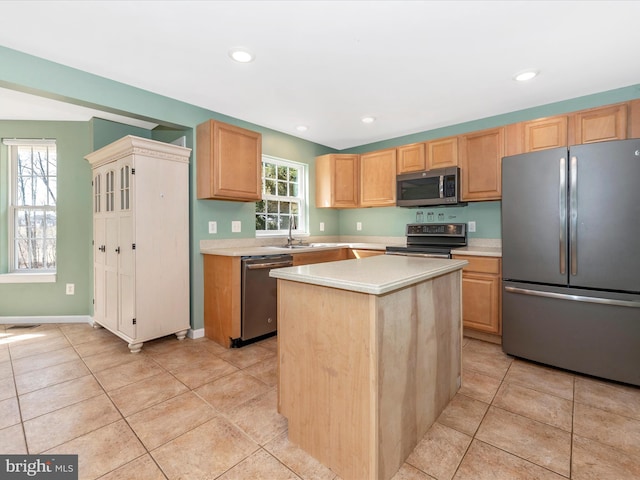 kitchen with stainless steel appliances, light tile patterned flooring, and light countertops