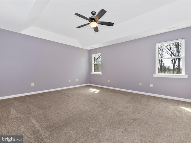 spare room with visible vents, lofted ceiling, carpet, baseboards, and ceiling fan