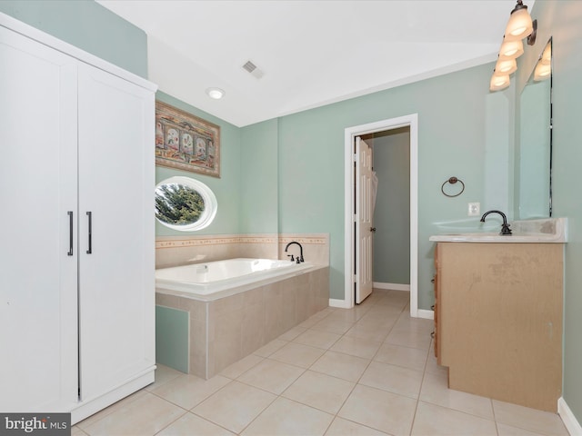 bathroom featuring tile patterned floors, visible vents, baseboards, lofted ceiling, and a bath