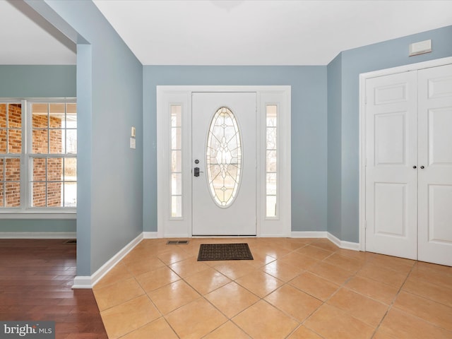 foyer with baseboards and light tile patterned flooring