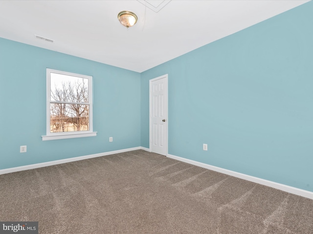 carpeted empty room featuring attic access, baseboards, and visible vents