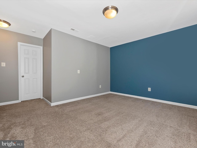 carpeted spare room with baseboards and visible vents