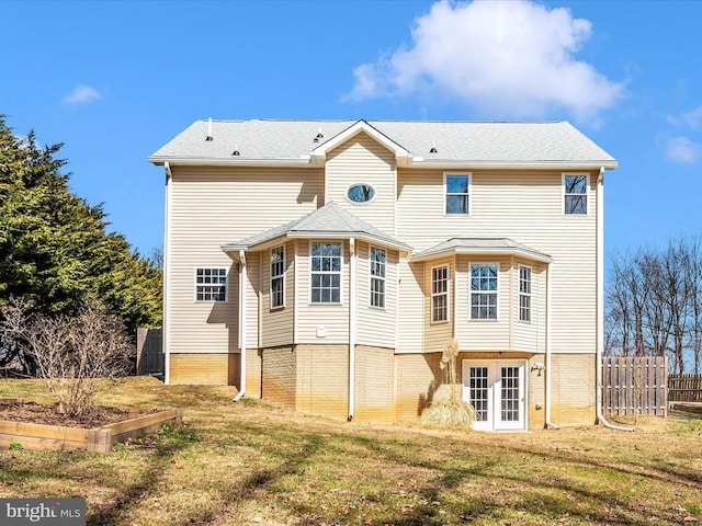 back of house with a vegetable garden, french doors, a yard, and fence