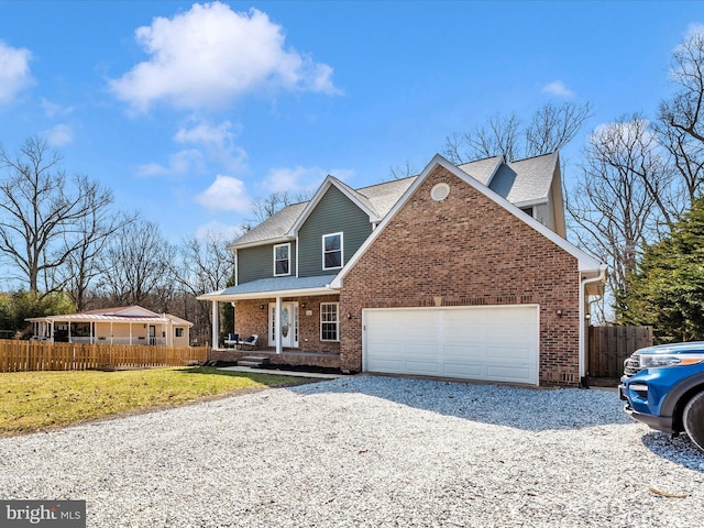 traditional-style house featuring brick siding, covered porch, an attached garage, and fence