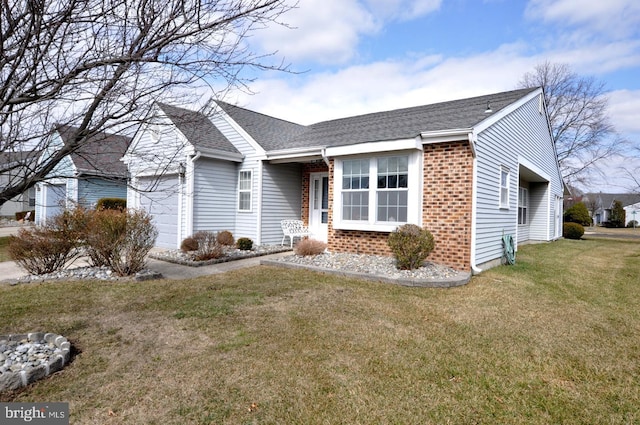 view of front of home with a front yard, brick siding, an attached garage, and roof with shingles