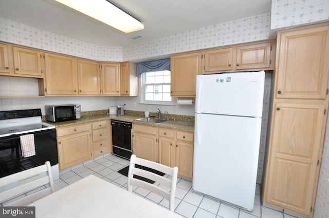 kitchen featuring electric range, a sink, black dishwasher, freestanding refrigerator, and wallpapered walls