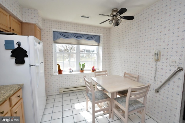 dining room featuring light tile patterned floors, visible vents, baseboard heating, and wallpapered walls