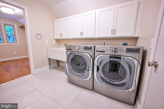 622 Hastings Rd, Baltimore, MD 21286 - laundry room featuring washing machine and clothes dryer, cabinet space, and light tile patterned floors
