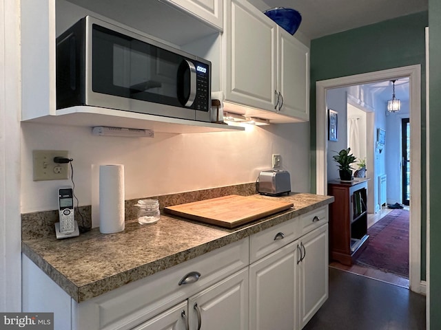 kitchen with white cabinets and stainless steel microwave