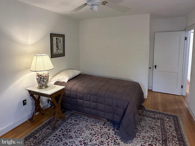 bedroom with wood finished floors, a ceiling fan, and baseboards