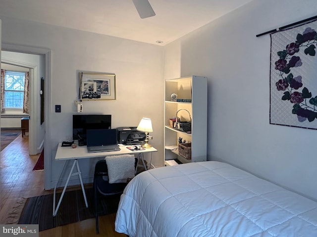 bedroom featuring ceiling fan, baseboards, and wood finished floors