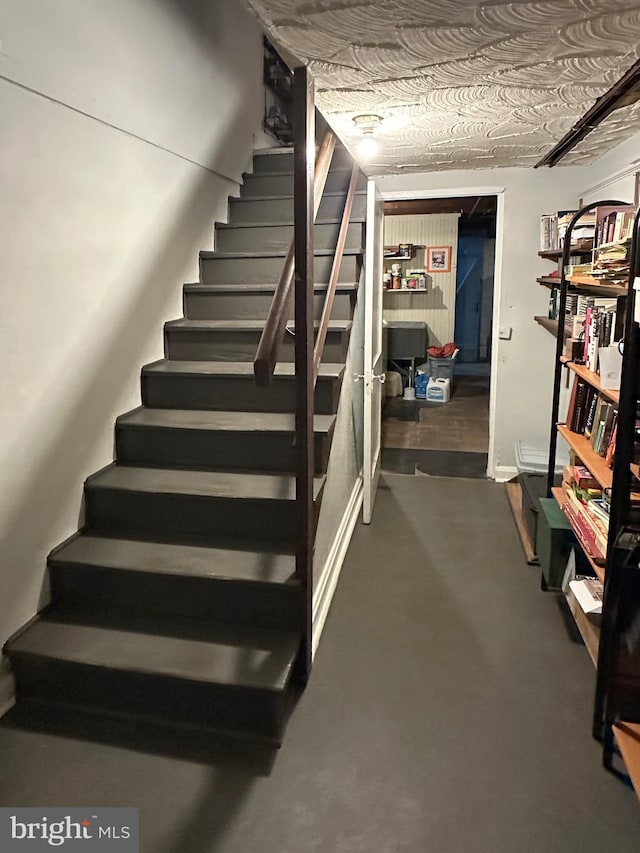 stairs with concrete flooring