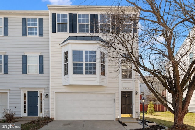 multi unit property featuring concrete driveway and a garage